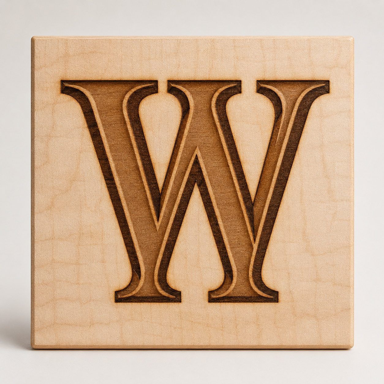 The Wimberly maker's mark, a slab-serif W branded into pale Tru-Oil-finished maple. The slightly fuzzed scorch edge is part of the mark.